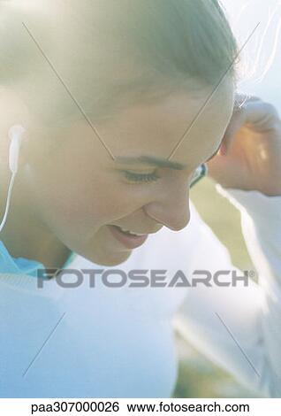 Teenage girl listening to earphones View Large Photo Image Stock Photograph - Teenage girl listening to earphones. Fotosearch