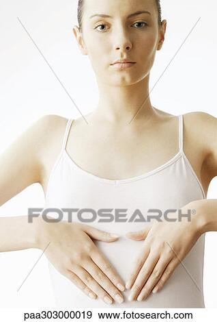Woman holding hands over stomach View Large Photo Image Stock Photo - Woman holding hands over stomach. Fotosearch