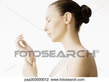Stock Image - Woman massaging wrist. Fotosearch