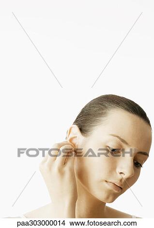 Picture - Woman touching ear. Fotosearch