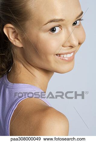 Woman looking over shoulder, smiling View Large Photo Image Stock Photo - Woman looking over shoulder, smiling. Fotosearch