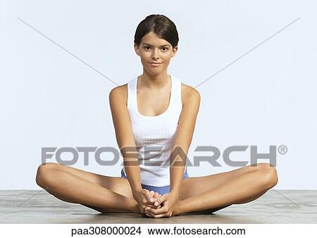 Woman sitting on floor stretching, in butterfly position View Large Photo Image Picture - Woman sitting on floor stretching, in butterfly position. Fotosearch