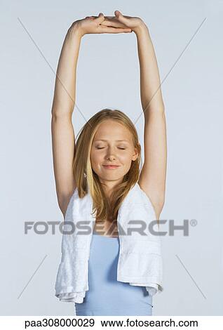 Woman stretching arms over head View Large Photo Image Stock Photo - Woman stretching arms over head. Fotosearch