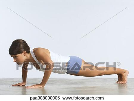 Stock Photography - Young woman doing push-ups. Fotosearch