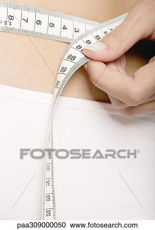 Woman measuring waist, extreme close-up View Large Photo Image Stock Image - Woman measuring waist, extreme close-up. Fotosearch