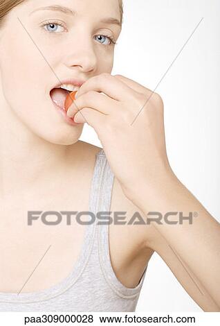 Young woman biting into tomato View Large Photo Image Stock Photo - Young woman biting into tomato. Fotosearch