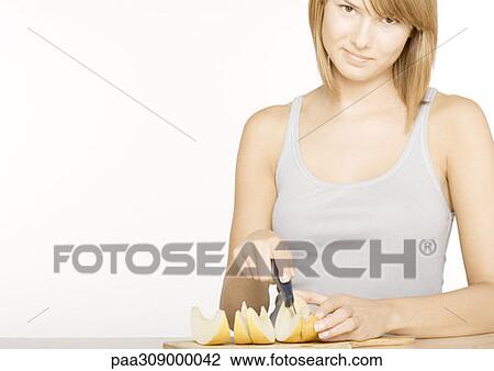 Young woman cutting up melon View Large Photo Image Stock Image - Young woman cutting up melon. Fotosearch