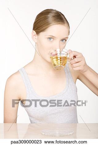 Young woman drinking herbal tea View Large Photo Image Stock Image - Young woman drinking herbal tea. Fotosearch
