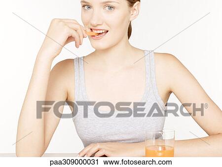 Young woman eating carrot stick and drinking carrot juice View Large Photo Image Stock Image - Young woman eating carrot stick and drinking carrot juice. Fotosearch