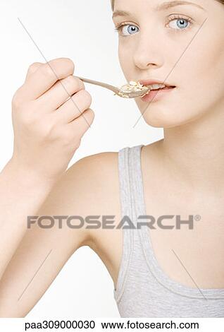 Young woman eating cereal View Large Photo Image Stock Image - Young woman eating cereal. Fotosearch