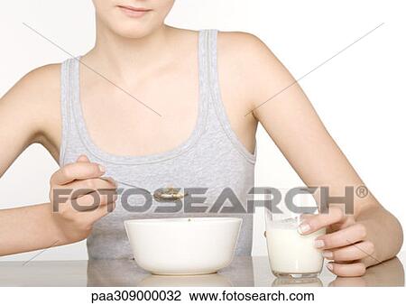Young woman eating cereal View Large Photo Image Stock Image - Young woman eating cereal. Fotosearch