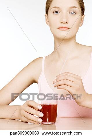 Young woman with glass of red juice View Large Photo Image Stock Photo - Young woman with glass of red juice. Fotosearch