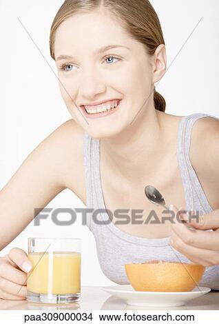 Young woman with grapefruit and glass of grapefruit juice View Large Photo Image Picture - Young woman with grapefruit and glass of grapefruit juice. Fotosearch