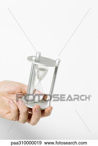 Stock Photo - Hand holding hourglass. Fotosearch