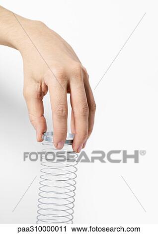 Hand holding metal coil toy View Large Photo Image Stock Image - Hand holding metal coil toy. Fotosearch