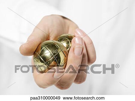 Stock Photo - Hand holding metallic balls. Fotosearch