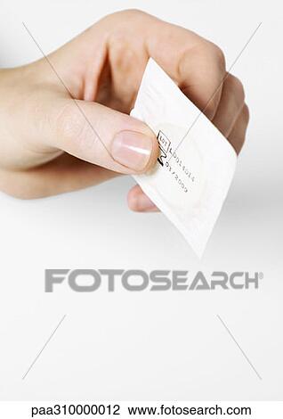 Hand holding out condom View Large Photo Image Stock Image - Hand holding out condom. Fotosearch