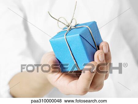 Stock Photo - Hand holding out small package. Fotosearch