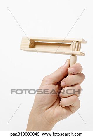Stock Image - Hand holding sport rattle. Fotosearch