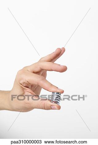 Stock Image - Hand holding spring. Fotosearch