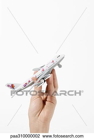 Stock Image - Hand holding toy airplane. Fotosearch
