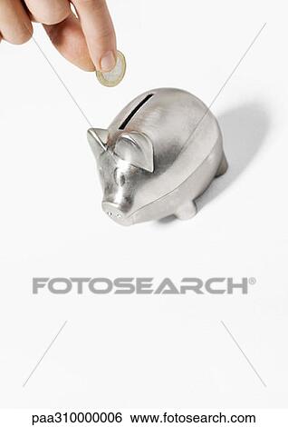 Stock Photograph - Hand inserting coin into piggy bank. Fotosearch
