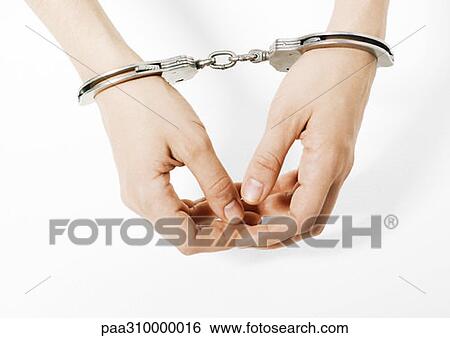 Stock Photograph - Handcuffed woman, close-up of hands. Fotosearch