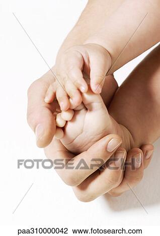 Stock Image - Woman holding baby's foot. Fotosearch