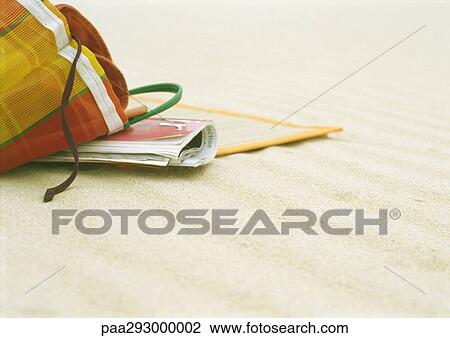 Stock Image - Beach bag and beach mat on beach. Fotosearch