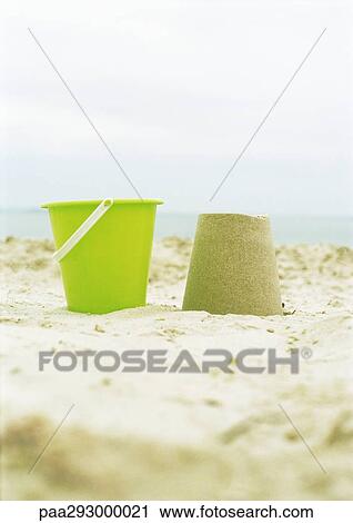 Bucket and molded sand on beach View Large Photo Image Stock Image - Bucket and molded sand on beach. Fotosearch