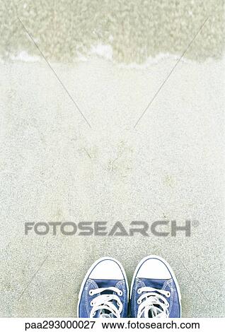 Stock Photo - Canvas shoes on beach. Fotosearch
