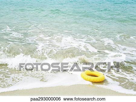 Innertube in surf on beach View Large Photo Image Stock Photograph - Innertube in surf on beach. Fotosearch