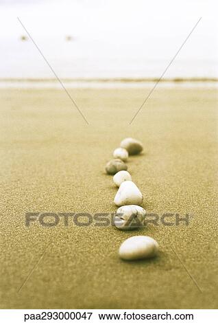 Stock Photo - Line of pebbles on beach. Fotosearch