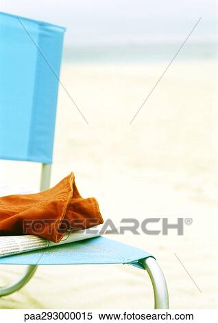 Newspaper and piece of clothing on beach chair View Large Photo Image Stock Photography - Newspaper and piece of clothing on beach chair. Fotosearch