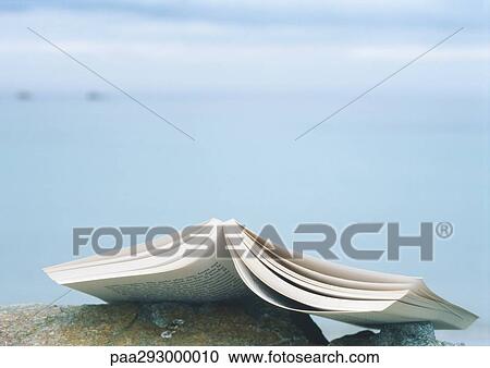 Open book laying face down on rock View Large Photo Image Stock Image - Open book laying face down on rock. Fotosearch