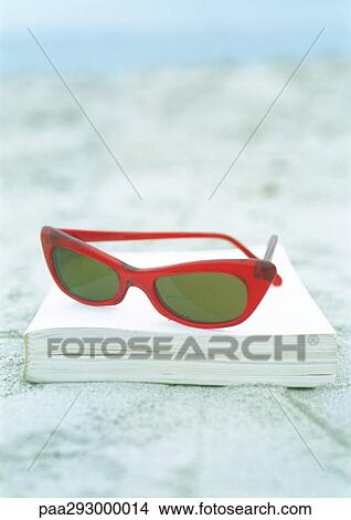 Sunglasses and book on sand View Large Photo Image Picture - Sunglasses and book on sand. Fotosearch