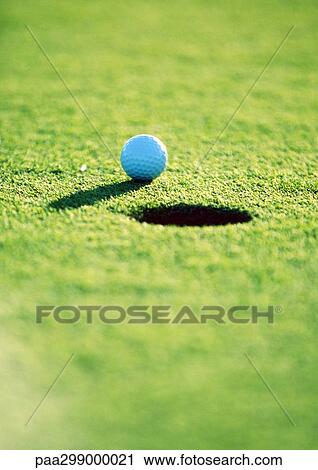 Golf ball near hole, close-up View Large Photo Image Stock Image - Golf ball near hole, close-up. Fotosearch