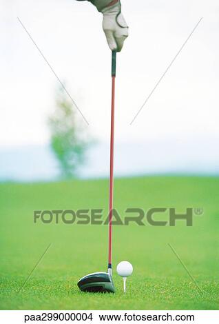Golfer holding club next to teed ball View Large Photo Image Picture - Golfer holding club next to teed ball. Fotosearch
