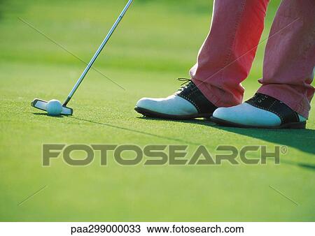 Stock Image - Golfer putting, close-up. Fotosearch
