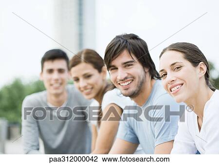 Group of young adults in urban park View Large Photo Image Stock Image - Group of young adults in urban park. Fotosearch