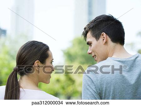 Young couple in urban park, rear view View Large Photo Image Picture - Young couple in urban park, rear view. Fotosearch