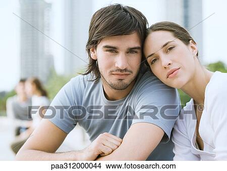 Young couple in urban park, woman resting head on man's shoulder View Large Photo Image Picture - Young couple in urban park, woman resting head on man's shoulder. Fotosearch