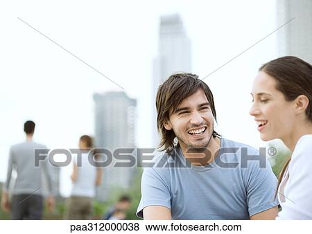 Young couple sitting in urban park View Large Photo Image Stock Photo - Young couple sitting in urban park. Fotosearch