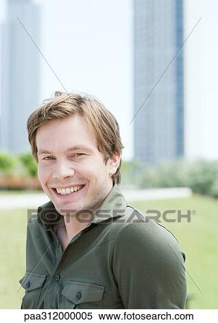 Young man in urban park, portrait View Large Photo Image Stock Photography - Young man in urban park, portrait. Fotosearch