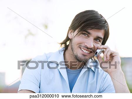 Young man using cell phone View Large Photo Image Stock Image - Young man using cell phone. Fotosearch