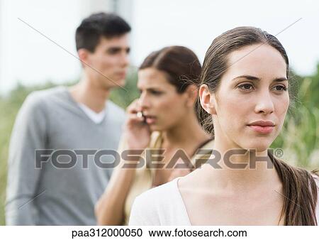 Stock Image - Young woman looking into the distance in park. Fotosearch