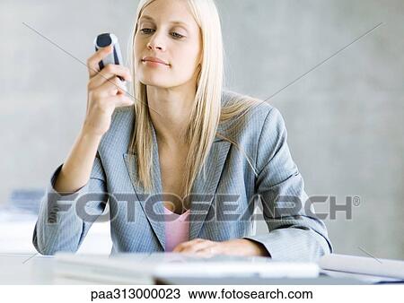 Businesswoman looking at cell phone View Large Photo Image Stock Image - Businesswoman looking at cell phone. Fotosearch