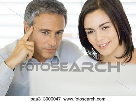 Stock Photo - Man and woman using computer. Fotosearch