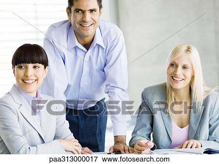 Three businesspeople in meeting, smiling View Large Photo Image Stock Photo - Three businesspeople in meeting, smiling. Fotosearch