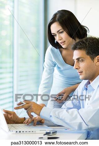 Woman and man working on laptop together View Large Photo Image Stock Image - Woman and man working on laptop together. Fotosearch
